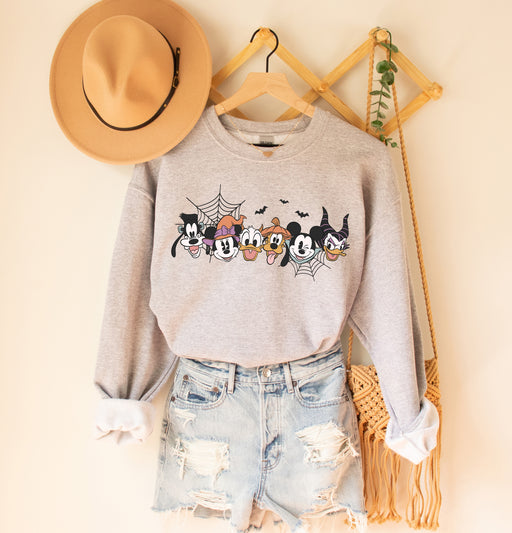 Festive sweatshirt featuring Mickey and friends in Halloween costumes.