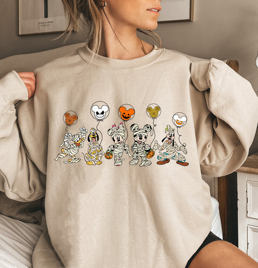 Fun sweatshirt featuring Mickey and friends as mummies with Halloween balloons.