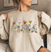 Fun sweatshirt featuring Mickey and friends as mummies with Halloween balloons.